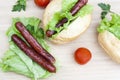 Hot dog. Grilled hot dogs with fresh salad lettuce on wooden table. Royalty Free Stock Photo