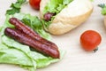 Hot dog. Grilled hot dogs with fresh salad lettuce on wooden table. Royalty Free Stock Photo