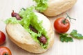 Hot dog. Grilled hot dogs with fresh salad lettuce on wooden table. Royalty Free Stock Photo