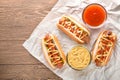 Hot dog with grilled sausage  mustard  and ketchup  onions  and greens on paper background Royalty Free Stock Photo