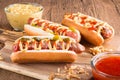 Hot dog with grilled sausage  mustard  and ketchup  onions  and greens on paper background Royalty Free Stock Photo