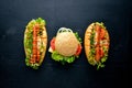 Hot dog and hamburger with cheese, meat and greens on Wooden background. Royalty Free Stock Photo