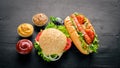 Hot dog and hamburger with cheese, meat and greens on Wooden background. Royalty Free Stock Photo