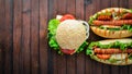 Hot dog and hamburger with cheese, meat and greens on Wooden background. Royalty Free Stock Photo