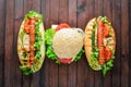 Hot dog and hamburger with cheese, meat and greens on Wooden background. Royalty Free Stock Photo