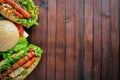 Hot dog and hamburger with cheese, meat and greens on Wooden background. Royalty Free Stock Photo