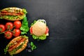 Hot dog and hamburger with cheese, meat and greens on Wooden background. Royalty Free Stock Photo