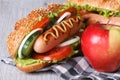 Hot dog with sausage and red apple close-up Royalty Free Stock Photo