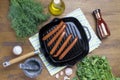 Hot dog sausages are fried in a grill pan, top view, greens, spices, Royalty Free Stock Photo