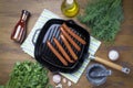 Hot dog sausages are fried in a grill pan, top view, greens, spices, Royalty Free Stock Photo