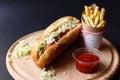 Hot Dogs with French fries and ketchup on wooden plate