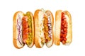 Hot dogs fully loaded with assorted toppings on a tray. Delicious hot-dogs with pork and beef sausages. Isolated on Royalty Free Stock Photo