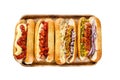 Hot dogs fully loaded with assorted toppings on a tray. Delicious hot-dogs with pork and beef sausages. Isolated on Royalty Free Stock Photo