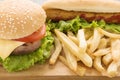 Hot dogs, hamburgers and french fries on the wooden background.