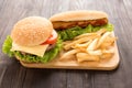 Hot dogs, hamburgers and french fries on the wooden background