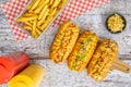 Hot dogs, french fries, and ketchup and mustard sauce jars on old wooden background. Top view Royalty Free Stock Photo