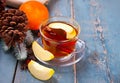 Drink of apple tea with cinnamon stick, star anise and clove. Seasonal punch in cup on wooden background