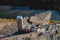 Hot drink in a gray thermos and two mugs is on the rocks. Coffee in the mountains. Close-up. Royalty Free Stock Photo