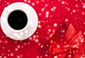 Winter holiday gift box, coffee cup and glowing snow on red flatlay background, Christmas time present surprise Royalty Free Stock Photo