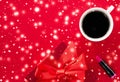 Winter holiday gift box, coffee cup and glowing snow on red flatlay background, Christmas time present surprise Royalty Free Stock Photo