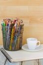 Hot Espresso coffee cup next to coloring colored pencils on sketch drawing book. . Royalty Free Stock Photo