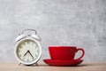 Hot espresso coffee and vintage clock on table, Red coffee cup in cafe or home in the morning. Activity, daily routine, morning, Royalty Free Stock Photo