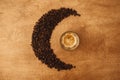 Hot espresso with foam in glass cup and aromatic roasted coffee beans in shape of moon on wooden table. Flat lay, Copy space. Royalty Free Stock Photo