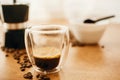 Hot Espresso in glass cup, roasted coffee beans, grounded coffee, geyser maker  on wooden table. Alternative Coffee brewing Royalty Free Stock Photo