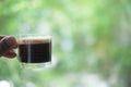Hot espresso shots in handle glass in hand Royalty Free Stock Photo