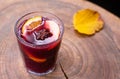 Hot and fragrant mulled wine in a glass on a wooden table. Seasonal warm drinks. Close-up. Selective focus