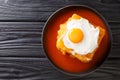 Hot Francesinha sandwich with sausages and meat, melted cheese, poured with tomato beer sauce and topped with a fried egg close-up Royalty Free Stock Photo