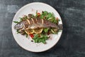 Hot fresh delicious roasted whole trout barbecue with fresh herbs and lemon, on a wooden background top view close-up Royalty Free Stock Photo