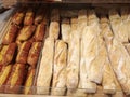 Hot freshly baked crisp french baguettes and fancy bread at storefront shelf