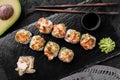 Hot fried Sushi rolls and maki set with smoked eel, cream cheese, avocado, caviar and wasabi on black slate background Royalty Free Stock Photo