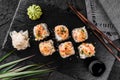 Hot fried Sushi rolls and maki set with smoked eel, cream cheese, avocado, caviar and wasabi on black slate background. Royalty Free Stock Photo