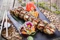 Hot fried Sushi rolls and maki set with smoked eel, cream cheese, avocado and wasabi on black stone on bamboo mat, selective focus Royalty Free Stock Photo