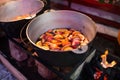 Hot gluhwein or mulled wine in a cauldron at fair, local treat, warm and spicy. A hot wholesome traditional citrus drink on fair. Royalty Free Stock Photo