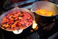 Hot gluhwein or mulled wine in a cauldron at fair, local treat, warm and spicy. A hot wholesome traditional citrus drink on fair. Royalty Free Stock Photo