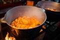 Hot gluhwein or mulled wine in a cauldron at fair, local treat, warm and spicy. A hot wholesome traditional citrus drink on fair. Royalty Free Stock Photo