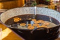 Hot gluhwein or mulled wine in a cauldron at fair, local treat, warm and spicy. A hot wholesome traditional citrus drink Royalty Free Stock Photo