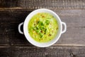 Hot green peas soup on the rustic background