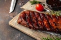 hot grilled spare ribs on cutting board on a dark background. American Spare Ribs in BBQ Sauce. Restaurant menu, dieting, cookbook Royalty Free Stock Photo