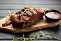 Hot grilled spare ribs from a summer BBQ served with a fresh tomatoes on an wooden cutting board