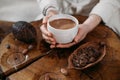 Person giving ceremonial cacao in cup. chocolate drink top view