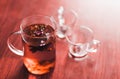 Hot brewed tea in transparent teapot and two cups on wooden background Royalty Free Stock Photo