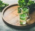 Hot herbal mint tea in glass mugs on wooden tray