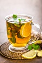 Hot herbal tea with fresh lemon, ginger and mint leaves on brown background, Royalty Free Stock Photo