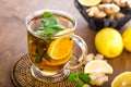 Hot herbal tea with fresh lemon, ginger and mint leaves on brown background, Royalty Free Stock Photo