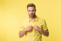 It is hot here. I will show you my body. Man handsome bearded guy undressing yellow background. Guy confident