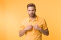 It is hot here. I will show you my sexy body. Man handsome bearded guy undressing yellow background. Guy confident